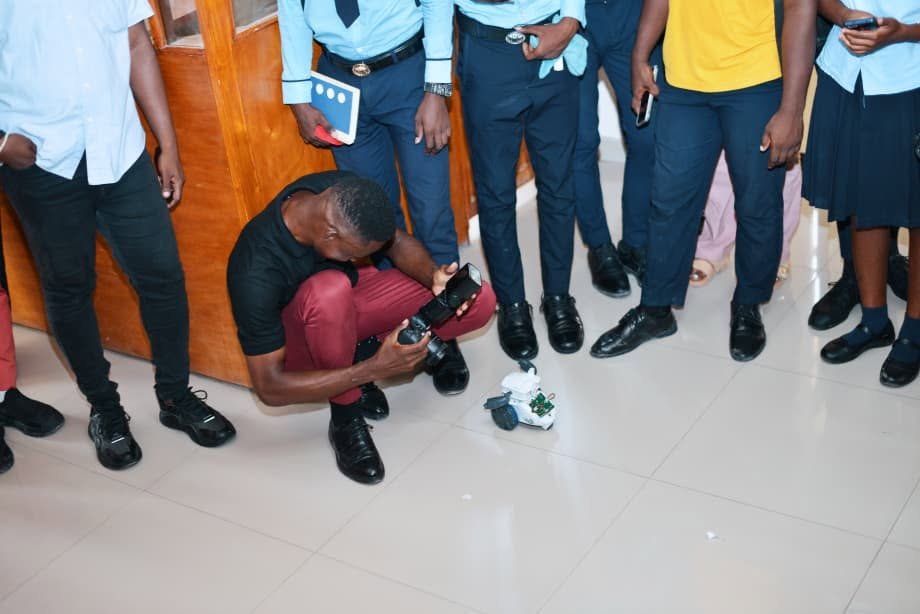 Démonstration de robotique devant des élèves en uniforme scolaire
