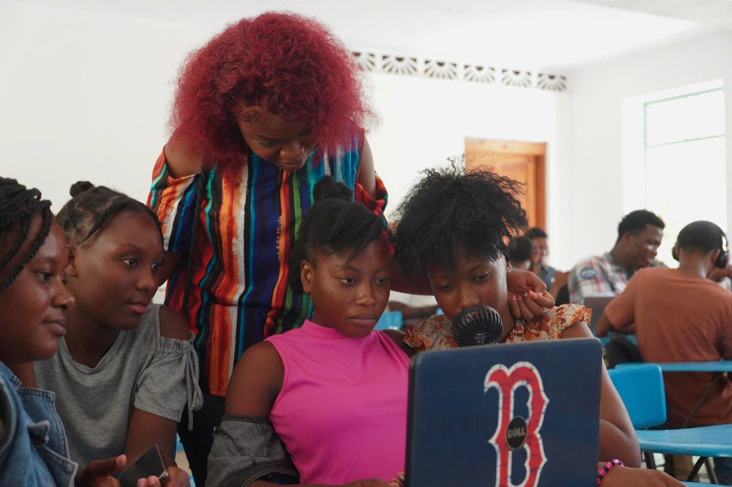 Mentore accompagnant un groupe de jeunes femmes autour d’un ordinateur