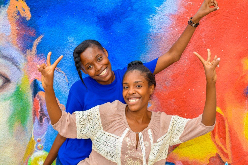 Deux membres du club Carrefour souriant devant une fresque